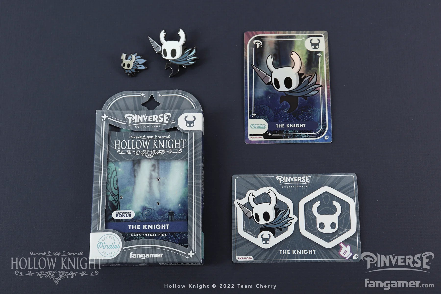 Hollow Knight merchandise including pins, cards, and packaging on a dark background